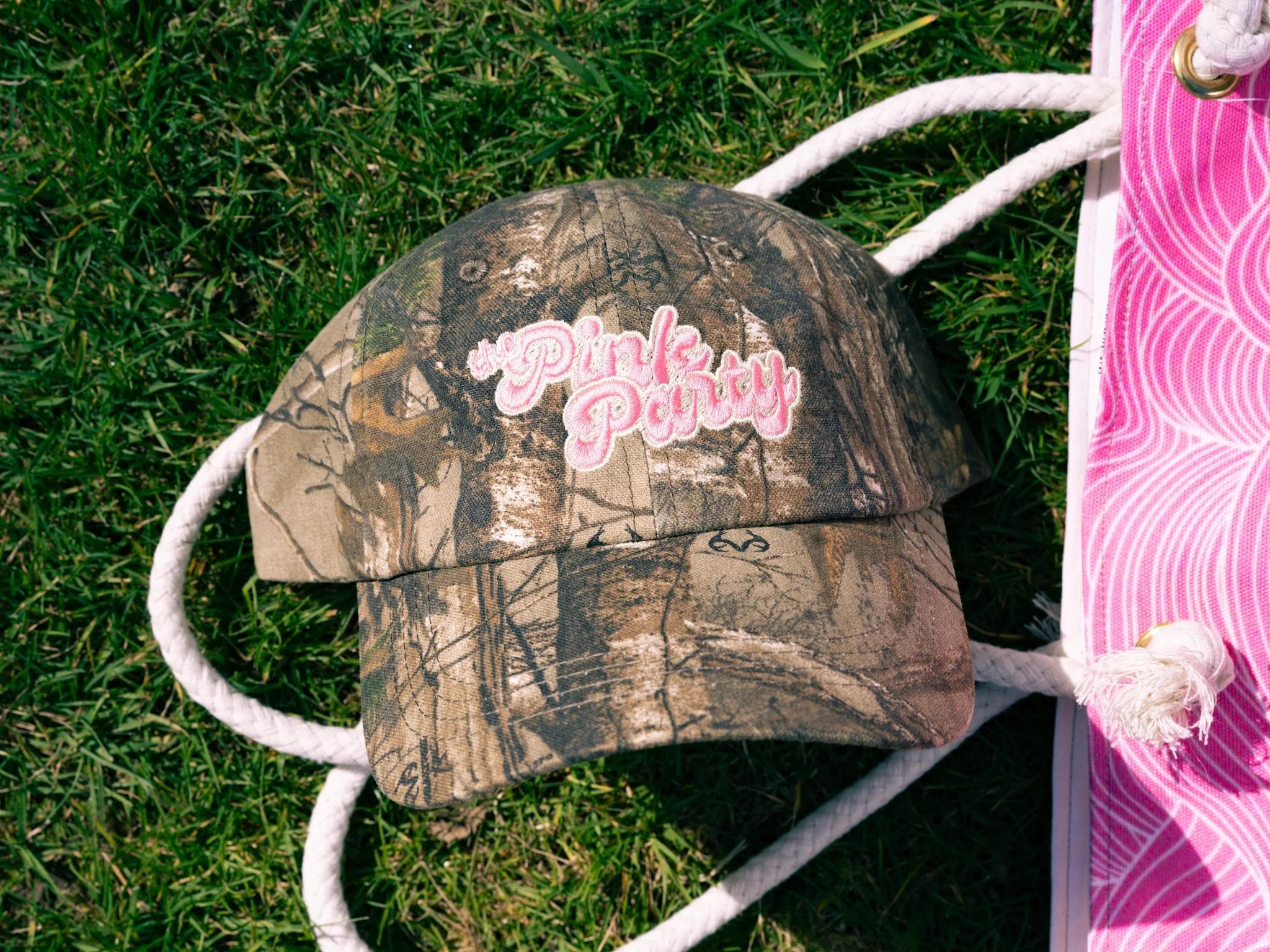 Women wearing a pink camo hat with a white t shirt